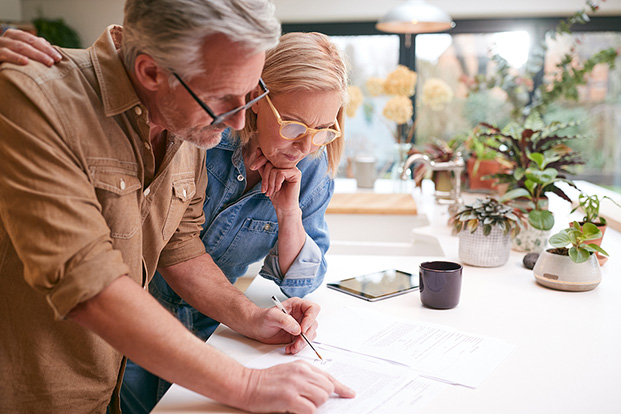Couple reviewing documents together at a kitchen counter